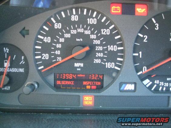 Car dashboard with speedometer, fuel gauge, and warning lights for oil service, inspection, and check engine