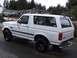 1996 Ford Bronco - This white 1996 Ford Bronco is shown from a rear three-quarter view on a wet street.