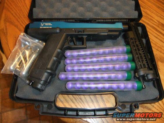 Paintball gun, five tubes of purple paintballs, and a speed loader in a case