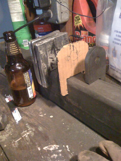 Metal bracket with cardboard template and beer bottle