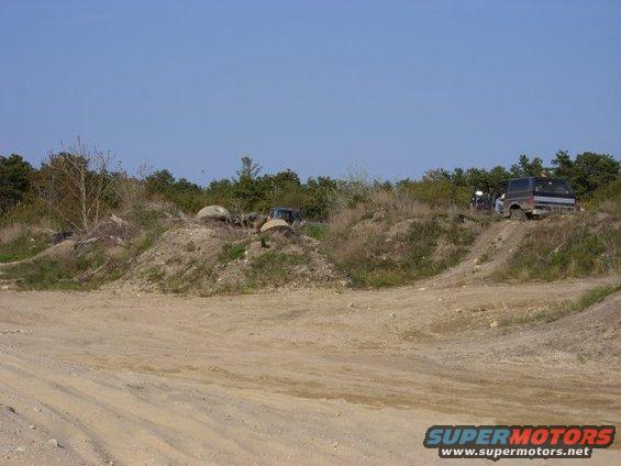 Dark blue 1992 Ford Bronco on a dirt hill, rear quarter view
