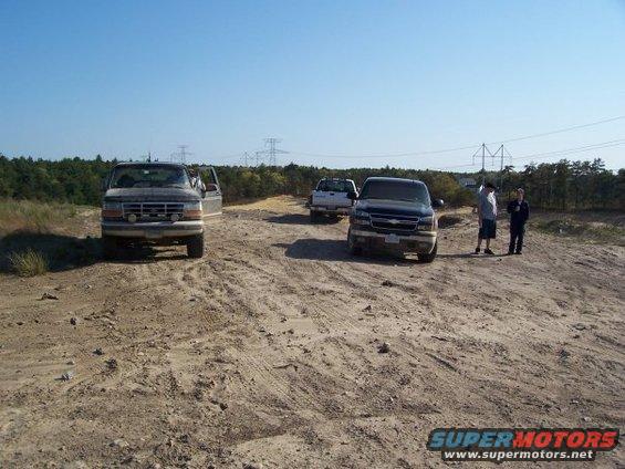 1994 Ford Bronco front view on dirt road with two other trucks