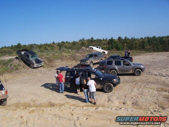 1994 Ford Bronco and other SUVs and trucks gathered on a dirt hill