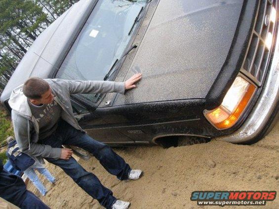 Black SUV stuck in sand, 3/4 front view