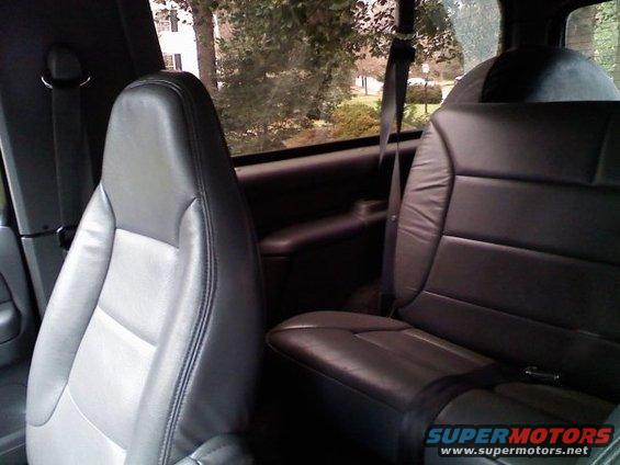 Interior view of black and gray leather seats with seatbelts