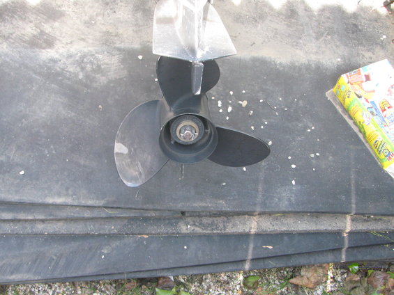 boat propeller on a dark surface, with a yellow package to the right