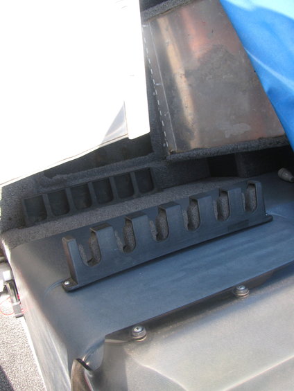 Boat interior with black rod holders and gray carpeted storage
