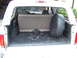 1996 Ford Bronco - Rear cargo area of a 1996 Ford Bronco, a spare tire and fold-down seat.