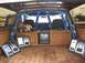 1986 Ford Bronco - Custom interior of an SUV a roll cage, entertainment system, and plush carpeting.