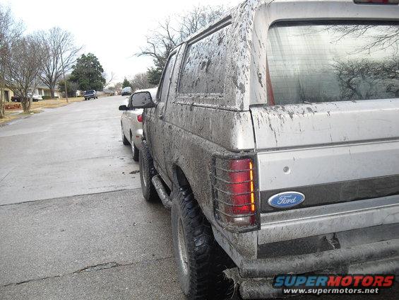 Mud-covered 1992 Ford Bronco rear view, showing taillight and Ford emblem