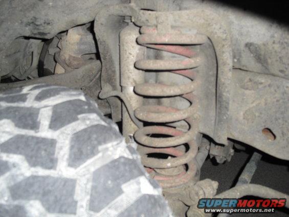 Tire and rusty coil spring assembly on a vehicle's suspension