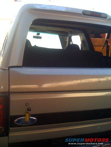 Rear view of a 1992 Ford Bronco with a Ford badge and a key in the lock