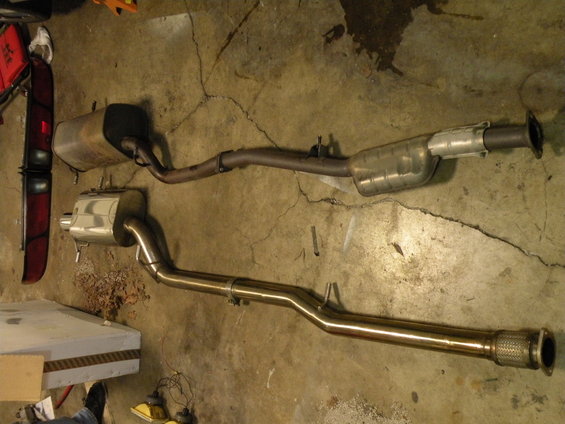 Stainless steel and stock exhaust systems on concrete floor