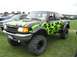 1986 Ford Bronco - A modified Ford Ranger pickup truck with custom flame decals sits on a grassy field at an outdoor event.