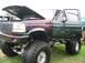 1986 Ford Bronco - This heavily modified Ford truck features a two-tone paint job and massive off-road tires.