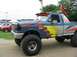 1986 Ford Bronco - This modified pickup truck features custom flame graphics and oversized tires, suggesting it's built for off-road performance.