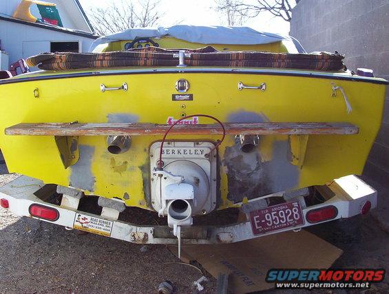 Rear view of a yellow boat with a Berkeley jet drive and a license plate E-95928