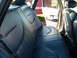 1997 Ford Crown Victoria - The interior of a vehicle is shown, focusing on the rear seats and the open passenger door.