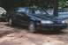 1987 Ford Thunderbird - A black 1987 Ford Thunderbird is parked in a dirt lot with trees and other vehicles visible.