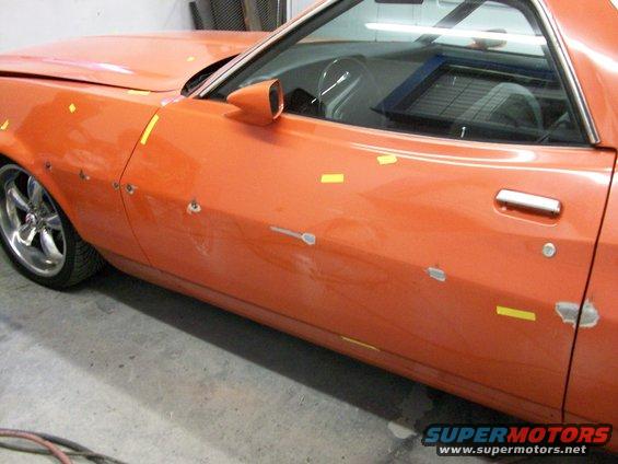 100_0316.jpg the black rub rail that ran down the length of the car got peeled off, we aren't going to re-install it when we are done, then the holes that were hidden behind it were  welded closed.