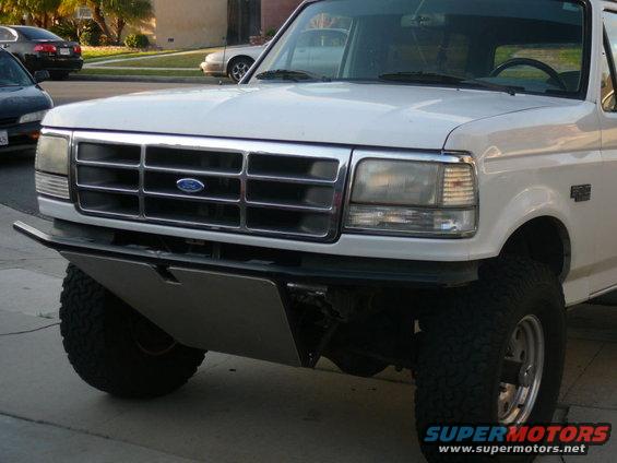 White Ford truck front view with chrome grille and aftermarket bumper