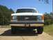 1989 Ford Bronco - White Ford F-Series truck, likely a 1987 model, seen from the front with a CAT emblem.