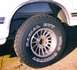 1989 Ford Bronco - Close-up of a tire and wheel assembly on a white vehicle, with visible text on the tire's sidewall.