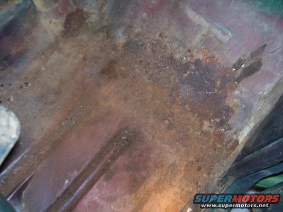 Pass side floor.  looks worse than it really is, just a few small holes and some loose rust.