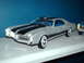 1978 Ford Mustang II - A silver coupe with black racing stripes and a blue interior is shown next to another vehicle.