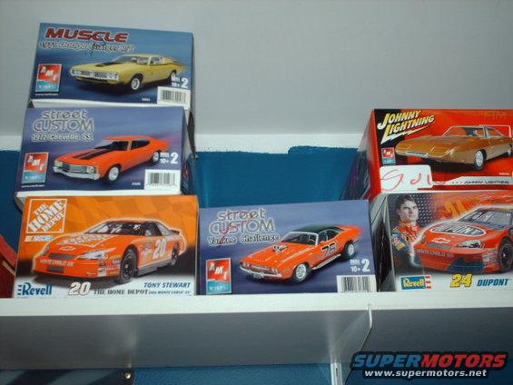 Several boxes of model cars, including a yellow 1971 Dodge Charger, an orange 1970 Chevrolet Chevelle SS, and a Tony Stewart NASCAR stock car