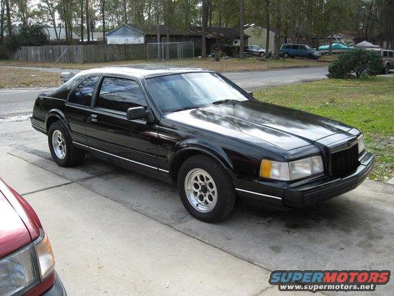 Black 1990 Lincoln Mark VII parked on a concrete driveway, front quarter view