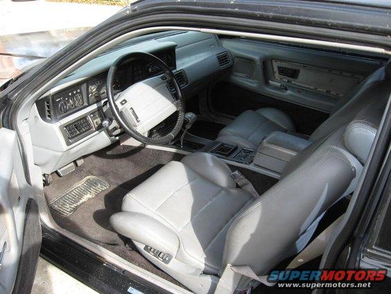 Interior view of a car with gray leather seats, dashboard, and steering wheel