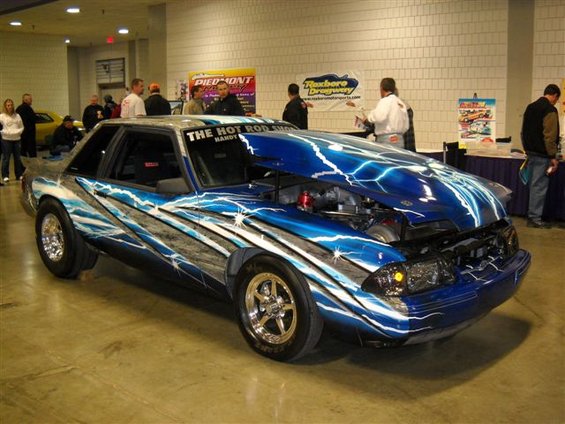 custom drag car with lightning bolt paint job, hood open showing engine