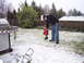1991 Ford Bronco - A man and a child stand in a snowy backyard next to a grill.