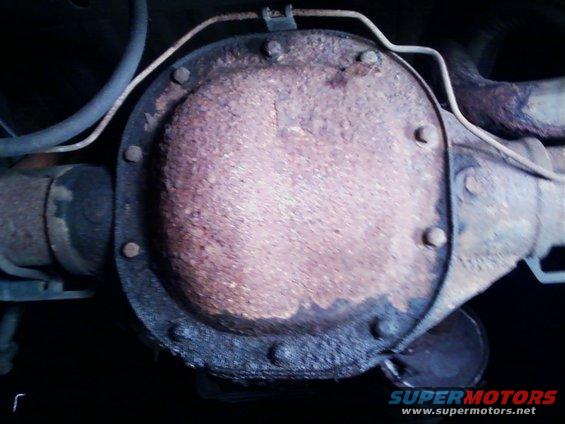 Rusty differential housing with bolts and exhaust pipe