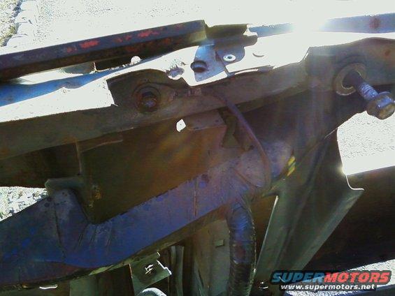 rusted metal frame and suspension parts with bolts and hoses
