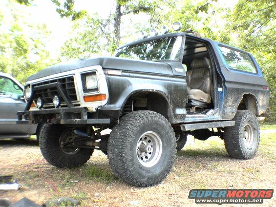 Modified 1978 Ford Bronco with off-road tires and custom bumper, driver's door open