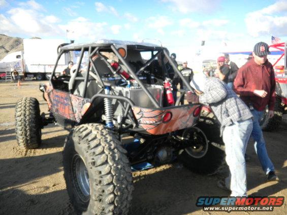 Rear view of a custom off-road buggy with large tires and a roll cage