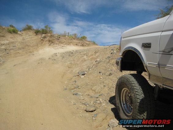1996 Ford Bronco on a rocky dirt road, front fender and tire visible