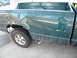 1995 GMC Sierra 1500 - The rear passenger side of a green pickup truck shows extensive damage to the body panels.