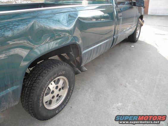 Green 1995 GMC Sierra 1500 pickup truck with significant rear quarter panel damage