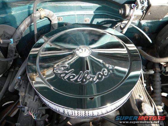 Engine bay with chrome Edelbrock air cleaner and green painted metal
