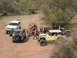 1996 Ford Bronco - A white SUV is parked in a dusty, outdoor area with several other off-road vehicles.