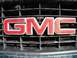 1995 GMC Sierra 1500 - Close-up of the red GMC emblem on the front grille of a 1995 GMC Sierra 1500.