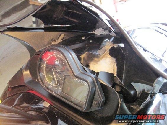 Yamaha logo on tachometer face, digital display, and damaged black fairing