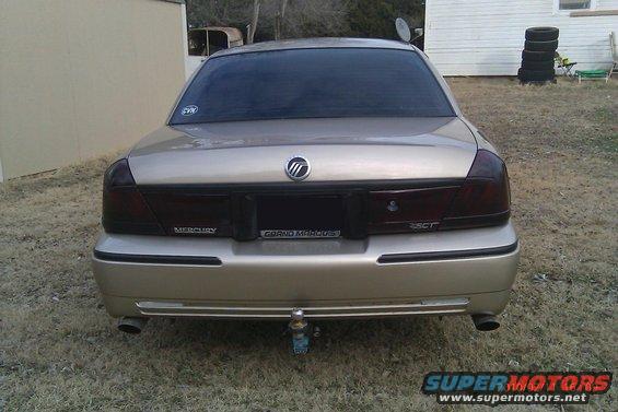 Gold 2000 Mercury Grand Marquis sedan, rear view, with tinted taillights and a trailer hitch