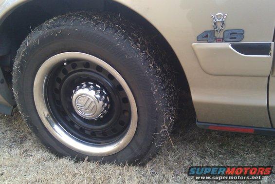 Tan car fender with a 4.6 badge and a steel wheel with a Mercury logo