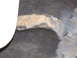 1995 Ford Bronco - A close-up view of a vehicle's wheel well shows a rusty suspension component against a dark background.
