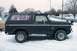 1979 Ford Bronco - This black Ford Bronco is parked outside in a snowy environment, showing its side profile.
