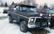 1979 Ford Bronco - A modified Ford Bronco sits in a snowy lot, equipped with auxiliary lights and a front plow.